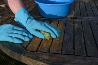 person cleaning different stains from their wooden furniture