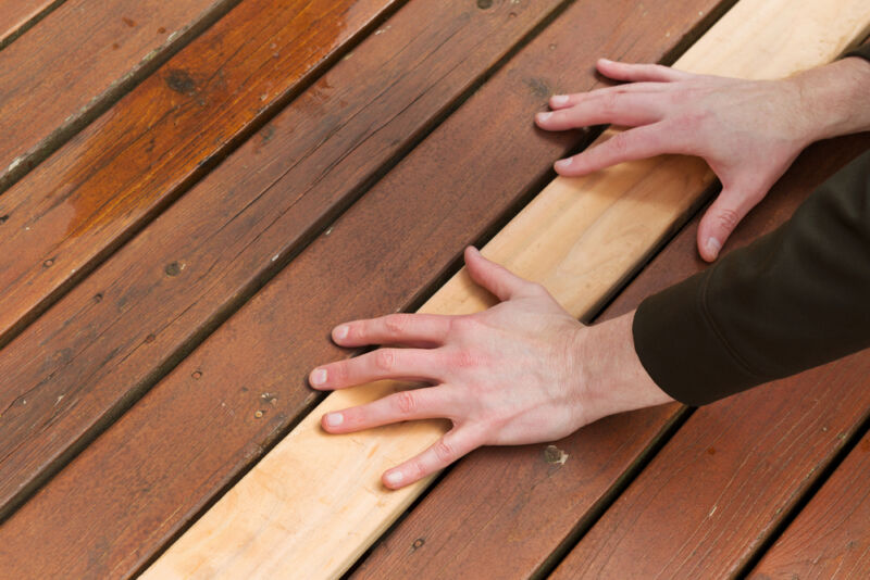 person finding out suitable sealant for outdoor wood